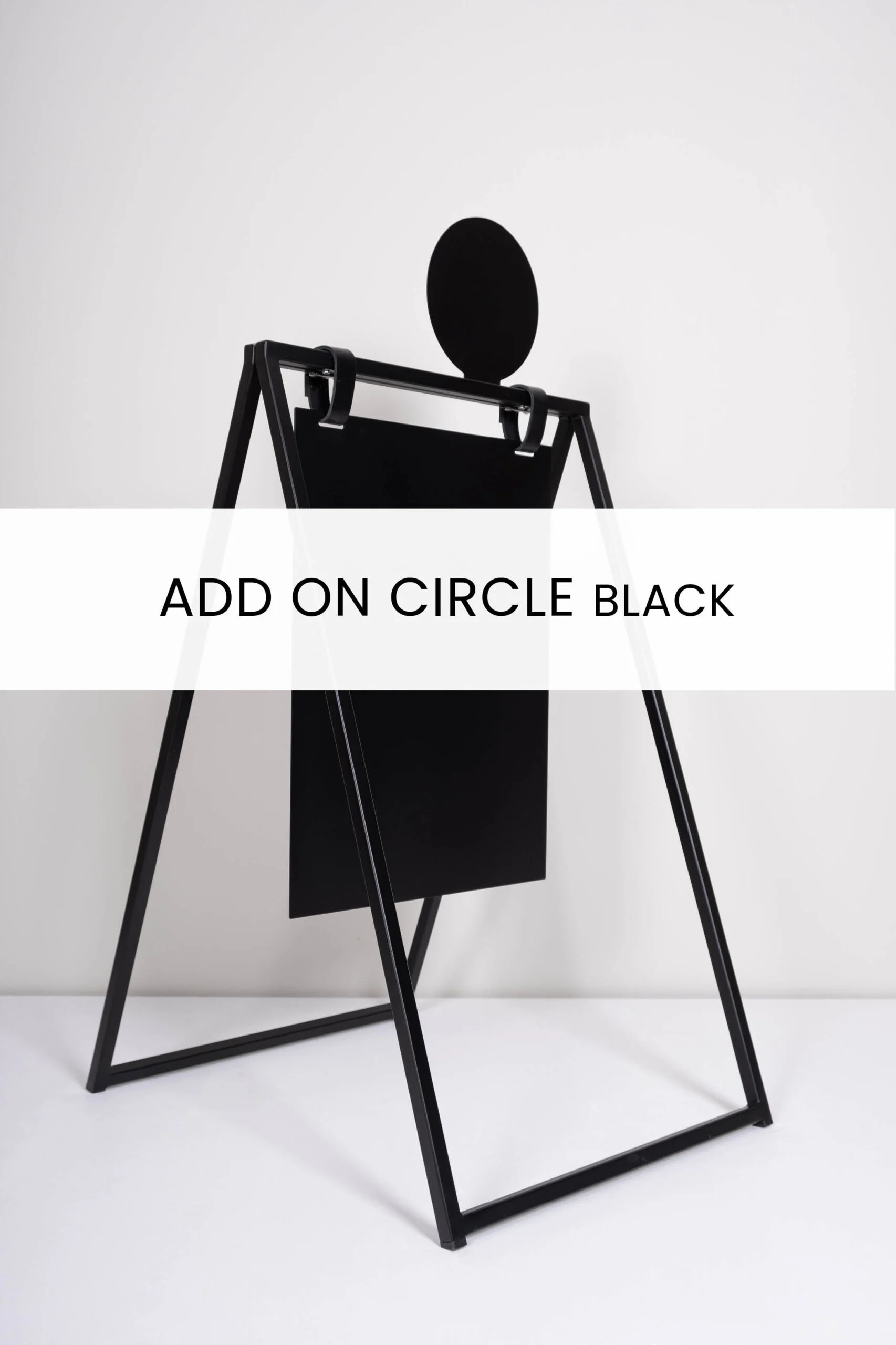Svadformad svart tavla med en rund överdel, designad som en del av ADD ON CIRCLE BLACK. Tavlan står på en stabil Ställning med svarta ben, placerad mot en ljus vägg.