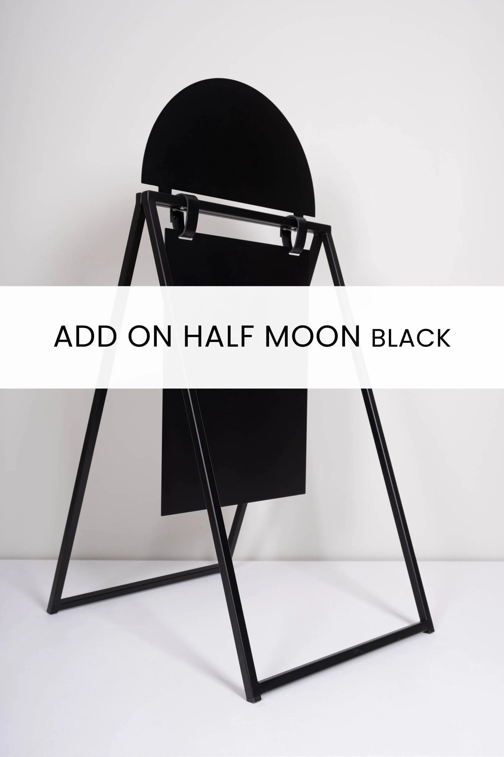 Svart ställning med en halvmåneformad topp och en rektangulär bakgrundsplatta, designad för att hålla meddelanden eller annonser. Produkten kallas ADD ON HALF MOON BLACK.